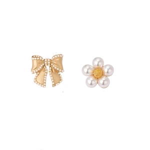 Elegant gold bow brooch with pearl flower detail on a clean white background