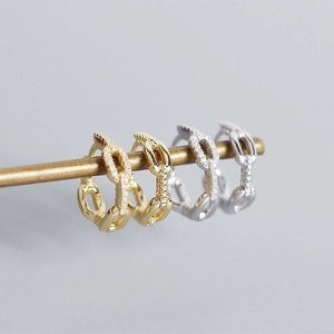 Close-up of gold and silver S925 sterling silver chain earrings with sparkling zircons