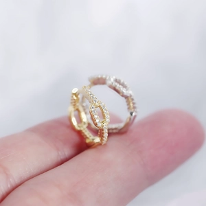 Close-up of gold and silver chain link hoops with small diamonds on fingers