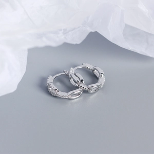Macro shot of silver chain hoop earrings with sparkling cubic zirconia and snap closure