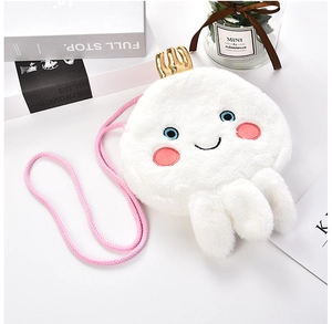 Detailed view of white plush jellyfish crossbody bag with gold crown and pink woven strap