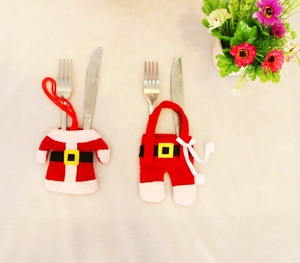 Detail of red knitted Christmas cutlery holder set featuring a mini jacket and trousers