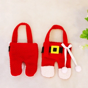 Detail of red knitted Christmas Santa pants utensil holders with mini belts and bows