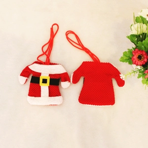 Detailed view of knitted Santa outfit cutlery holders on a textured festive background
