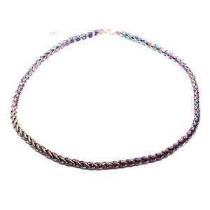 Detailed macro view of an iridescent rainbow punk hip hop woven chain necklace