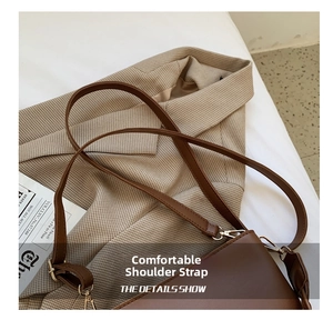 Detail of comfortable thin shoulder strap and silver metal buckle on brown leather bag
