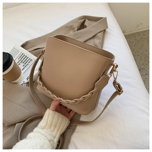 Khaki bucket bag with woven handle shown with coffee and blazer for a commuter style