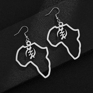 Detail of silver stainless steel African map earrings with Gye Nyame symbol on leather background