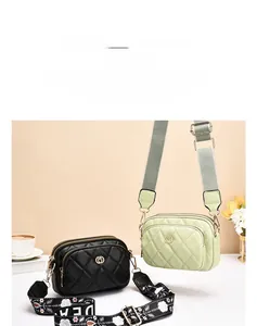 Detail of quilted leather bags in black and light green with decorative wide shoulder straps