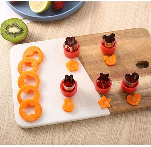 Detail showing 4-piece stainless steel vegetable cutters with red handles on a board