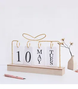 Detailed view of the wooden desktop perpetual calendar with golden metal arch and cards