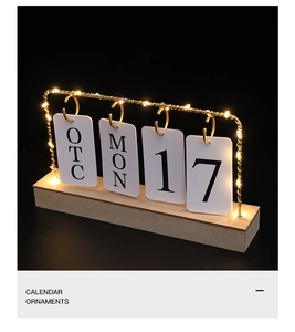 Detail of wooden perpetual calendar with warm LED lights and golden metal flip cards