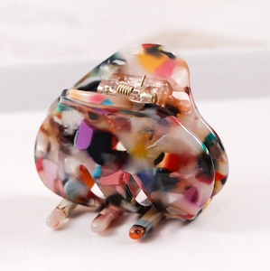 Detailed view of large acetate hair claw clip with colorful marbled pattern finish