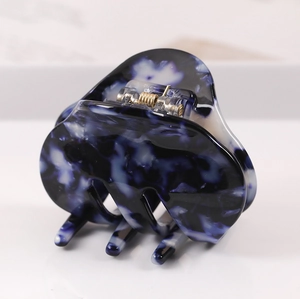 Detail shot of the sturdy gold metal spring and blue marble pattern hair claw clip