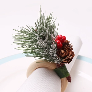 Christmas pine cone napkin ring with red berries and snowy needles on wooden base