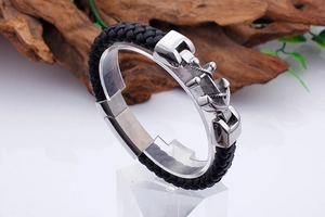 Detailed close-up of a stainless steel anchor magnetic clasp on a braided leather bracelet