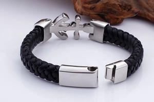 Close-up of black braided leather men's bracelet with a silver stainless steel anchor clasp