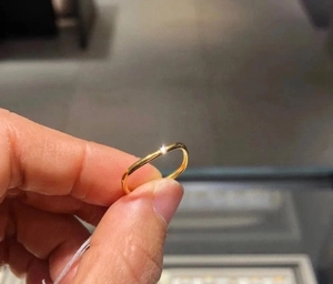Detailed view of a slim gold-tone titanium square ring featuring a high-polish finish