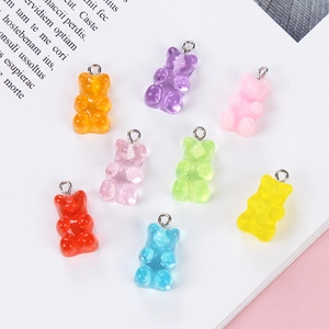 Flat lay of colorful glitter resin gummy bear charms with metal loops for DIY jewelry