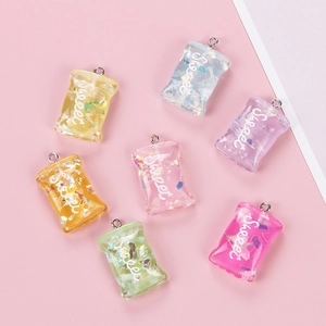 Close-up of colorful resin candy bag charms with glitter and Sweet text in various colors