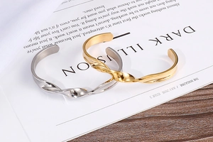 Detailed view of twisted spiral metal bracelets in gold and silver on a magazine
