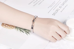 Close-up of silver twist rope bangle worn by model in a stylish lifestyle setting