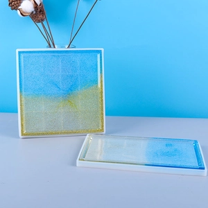 Macro view of square and rectangular silicone resin molds with blue gold coaster resin art