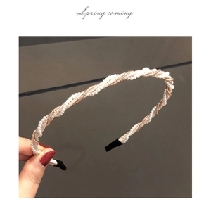 Close-up of braided pearl and rose gold metal wire headband with a Spring coming text