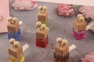 Close-up of square colorful glass car perfume bottles with wood caps and clips