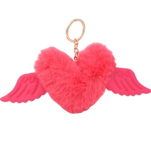 Pink plush heart keychain with wings and gold metal ring on white background