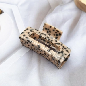 Detail of cream leopard print acetate hair claw clip with strong metal spring