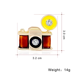 Vintage camera brooch with colorful enamel and crystal accents on a white background
