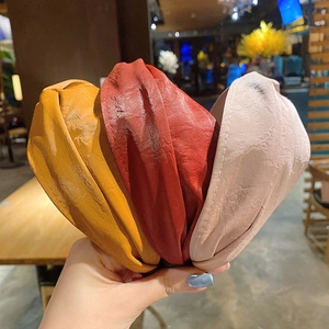 Detailed view of vintage knotted PU leather headbands in red, yellow, and pink colors