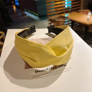 Close-up of yellow wide leather headband with twisted knot design and anti-slip lining