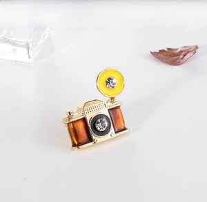Close-up of vintage camera brooch with colorful enamel and sparkling rhinestones