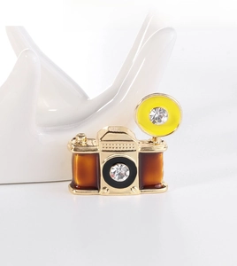 Detailed view of vintage camera brooch with brown enamel and sparkling rhinestones