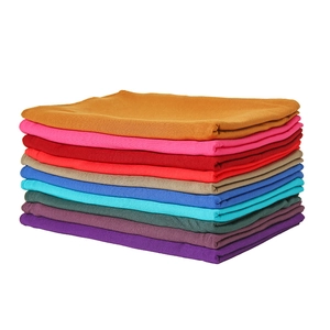 Stack of colorful silky cotton scarves for women in ten vibrant solid shades