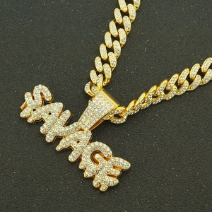 Goldene Gliederkette mit vereistem SAVAGE-Buchstabenanhänger auf schwarzem Grund