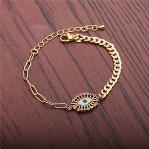 Punk style gold Evil Eye bracelet with colorful cubic zirconia on a wooden background