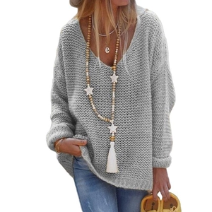 Close-up of grey chunky knit sweater featuring a deep V-neck and wooden star pendant