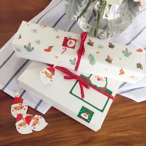Christmas gift box set with Santa tags, stickers and red polka dot ribbons on a wooden table