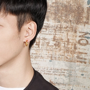 Polished golden stainless steel hoop earrings for men shown on male model ear