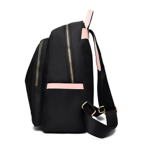 Side view of a waterproof black nylon backpack with stylish pink straps and gold-tone zippers