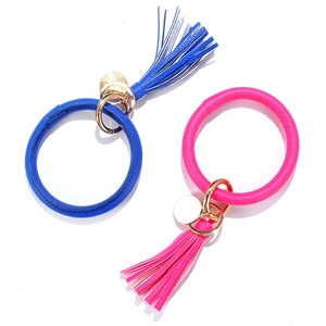 Detail of blue and pink faux leather keychain bracelets with tassels and metal tags