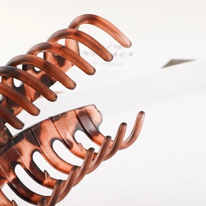 Detailed macro view showing the brown amber texture and teeth of the large plastic hair claw