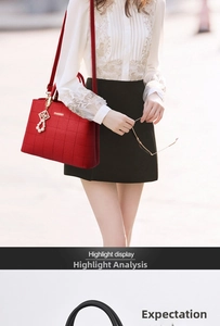 Detail of red embroidered leather tote bag with pearl charm and golden hardware detail
