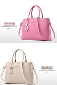 Detail of pink and cream faux leather handbags with quilted stitching and pearl charm