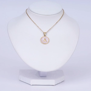Close-up of 18k gold-plated stainless steel necklace with pink shell letter A pendant