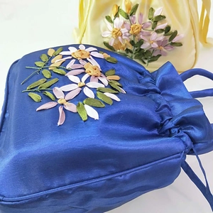 Detailed view of satin drawstring bags with exquisite ribbon floral embroidery work