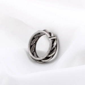 Bague rétro en argent oxydé avec texture tressée sur un tissu blanc doux